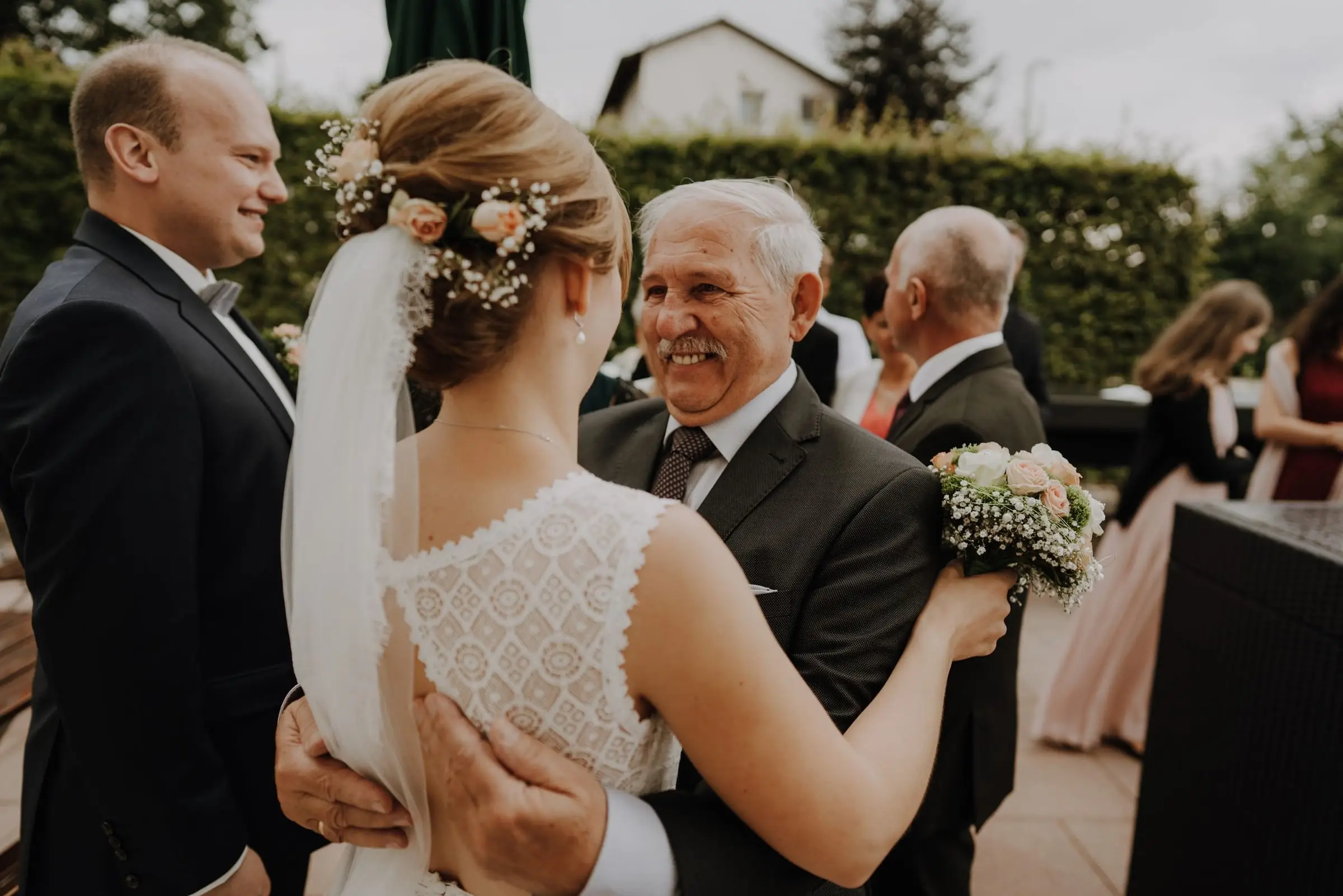 Braut umarmt bei der Gratulation einen älteren Gast